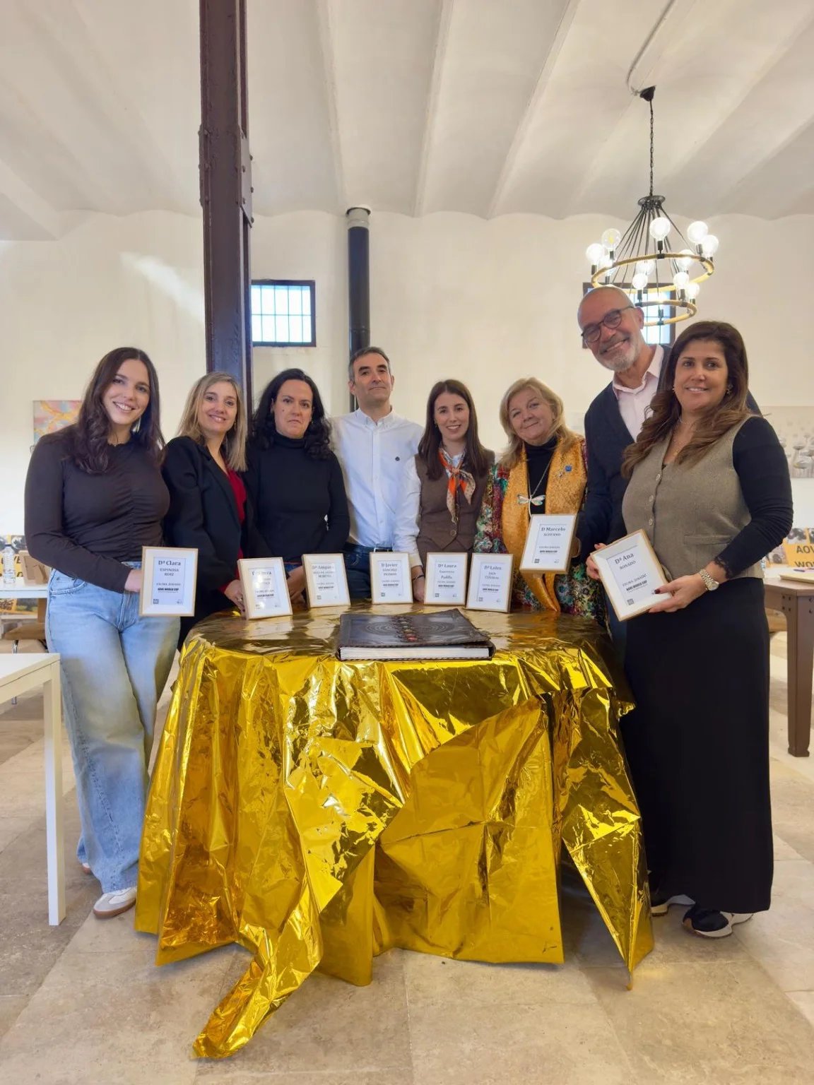 Fotografía de grupo alrededor de una mesa del certamen